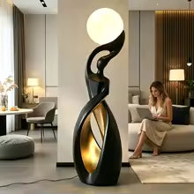 Woman using a laptop in a modern living room with a decorative floor lamp.