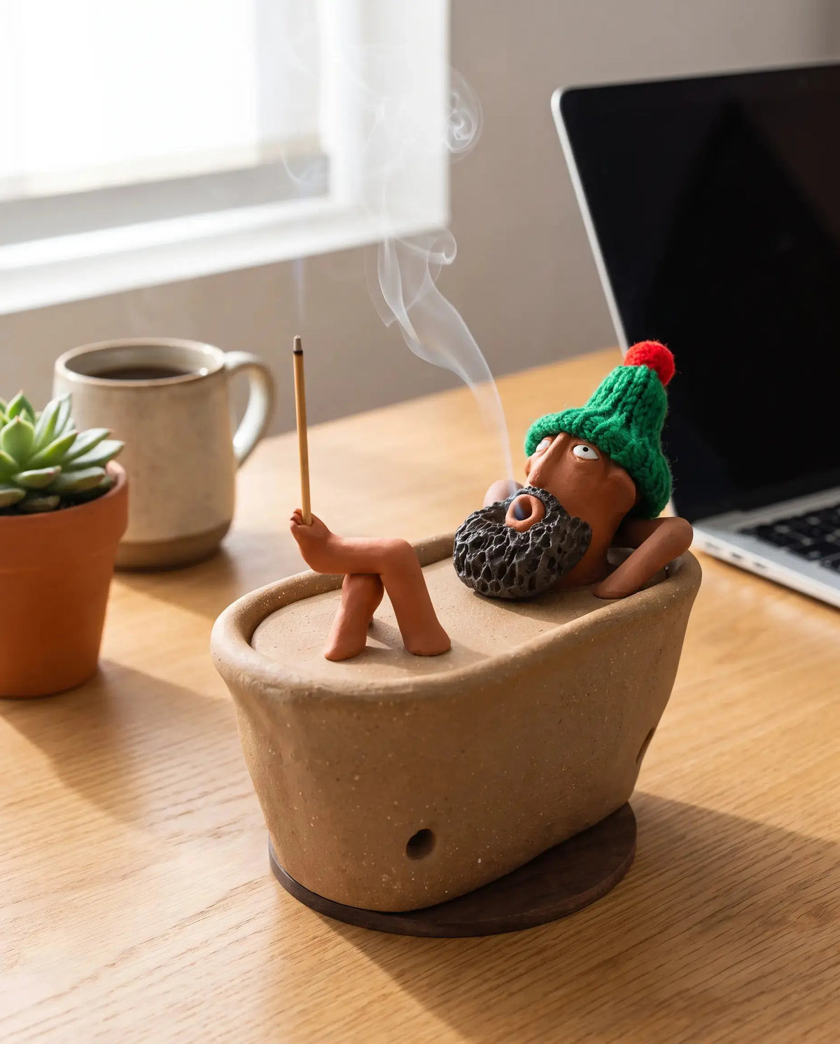 Lazy Bath Man incense burner on a home office desk
