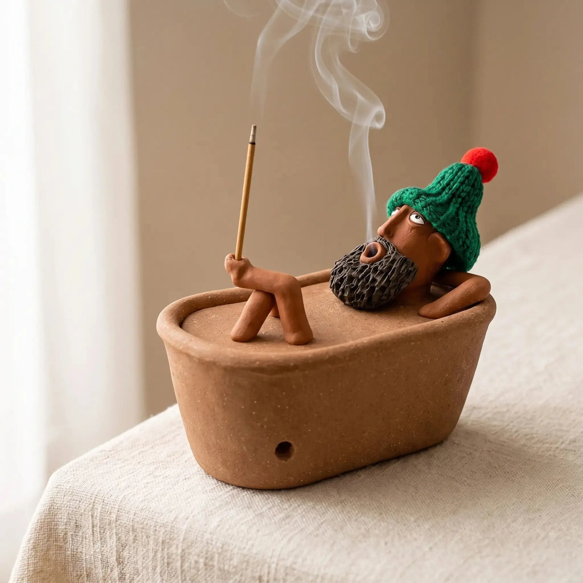 Lazy Bath Man incense burner with smoke rising from his mouth
